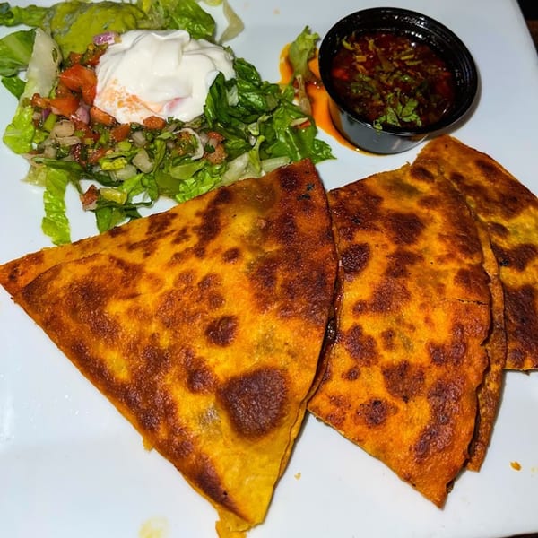 El Patron Mexican Restaurant's quesadillas with a side of salad, sour cream, and salsa.